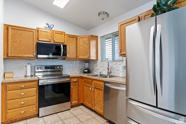 771 N 1725 W, Clinton, UT 84015 - kitchen featuring appliances with stainless steel finishes, lofted ceiling, light countertops, backsplash, and light tile patterned floors
