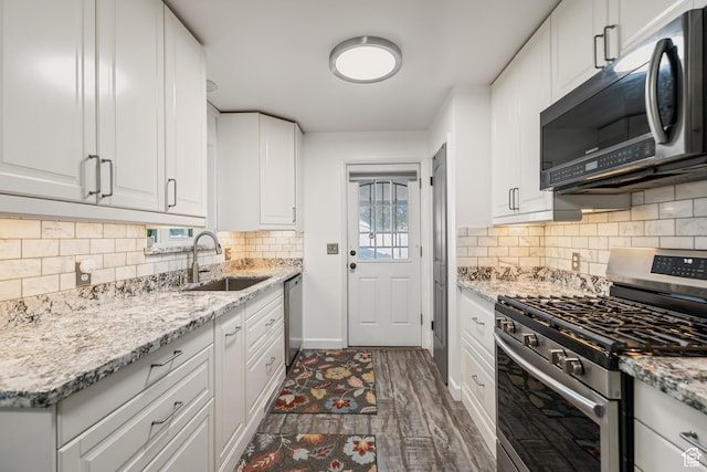 174 W Dawson St, Layton, UT 84041 - kitchen with appliances with stainless steel finishes, white cabinetry, tasteful backsplash, and light stone countertops