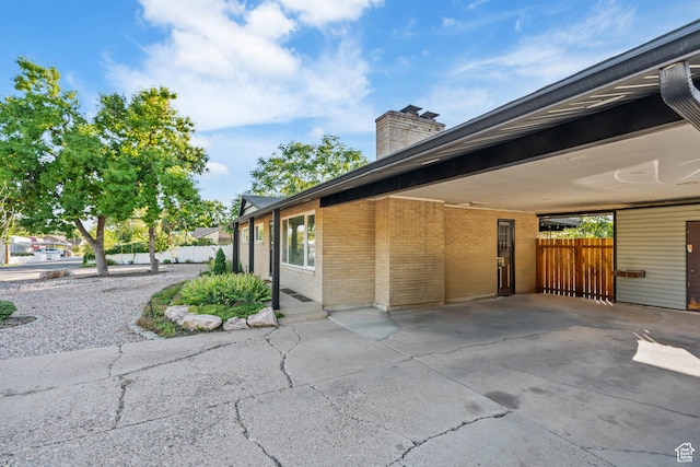174 W Dawson St, Layton, UT 84041 - view of property exterior with brick siding, a chimney, and a carport