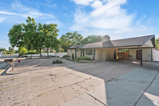 174 W Dawson St, Layton, UT 84041 - view of front of home with a chimney, a carport, driveway, brick siding, and roof with shingles