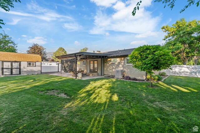 174 W Dawson St, Layton, UT 84041 - rear view of house with a patio, a fenced backyard, an outbuilding, brick siding, and french doors