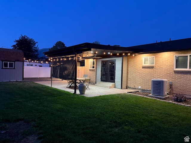 174 W Dawson St, Layton, UT 84041 - back of property featuring a patio area, brick siding, a lawn, and a storage shed