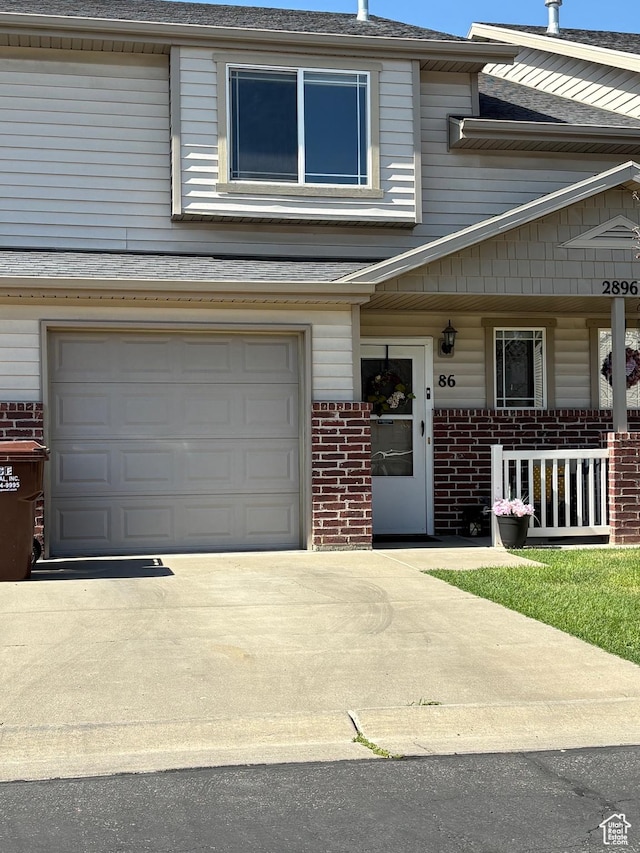 2896 W 3965 S Unit 86, West Haven, UT 84401 - view of front of property with brick siding, driveway, covered porch, and an attached garage