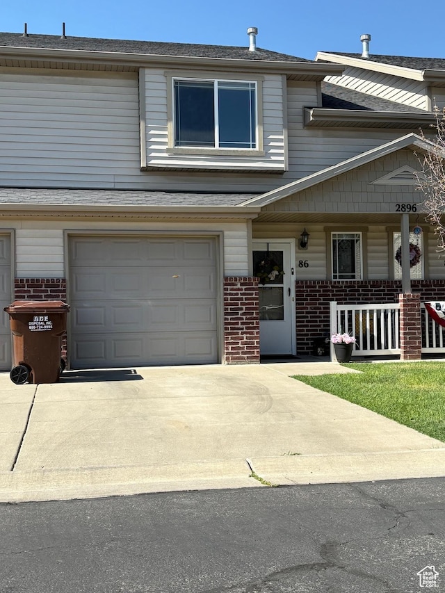 2896 W 3965 S Unit 86, West Haven, UT 84401 - townhome / multi-family property featuring brick siding, an attached garage, driveway, a shingled roof, and a porch