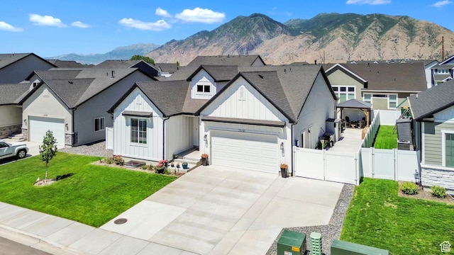 2456 W Maple St, Mapleton, UT 84664 - view of front of home with board and batten siding, a gate, an attached garage, driveway, and a mountain view