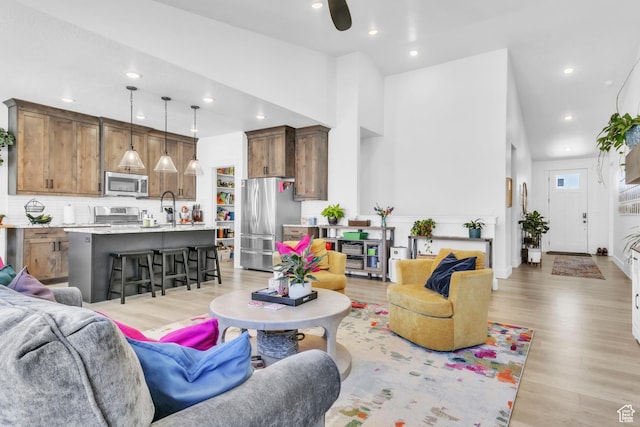2456 W Maple St, Mapleton, UT 84664 - living area with light wood-style floors, recessed lighting, ceiling fan, and a towering ceiling