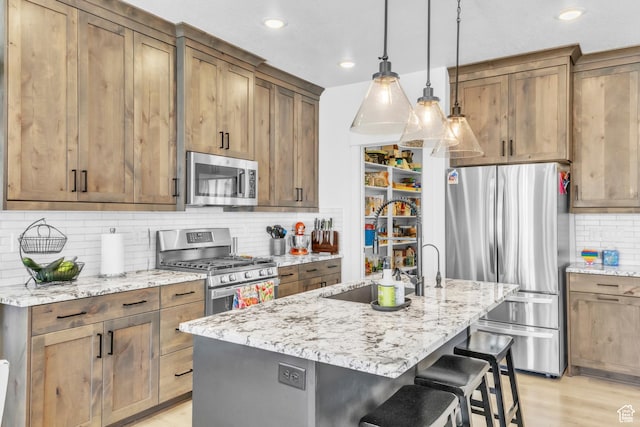 2456 W Maple St, Mapleton, UT 84664 - kitchen featuring appliances with stainless steel finishes, decorative backsplash, a breakfast bar area, light stone countertops, and recessed lighting