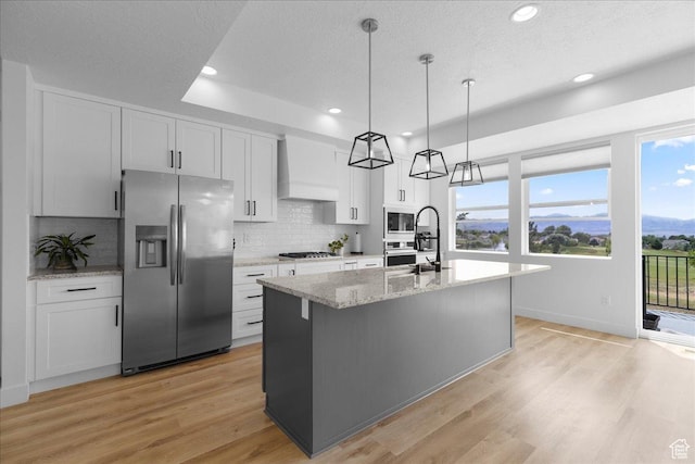 469 N 1360 E Unit 13, Tooele, UT 84074 - kitchen featuring stainless steel appliances, custom range hood, tasteful backsplash, a kitchen island with sink, and recessed lighting