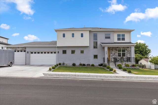 469 N 1360 E Unit 13, Tooele, UT 84074 - view of front of house with an attached garage, covered porch, a front lawn, driveway, and stone siding