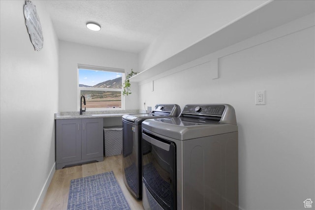 469 N 1360 E Unit 13, Tooele, UT 84074 - washroom featuring washer and dryer, light wood finished floors, cabinet space, and a textured ceiling