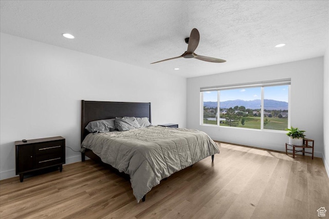 469 N 1360 E Unit 13, Tooele, UT 84074 - bedroom with light wood-style flooring, a textured ceiling, recessed lighting, a mountain view, and ceiling fan