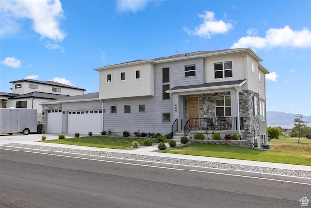 469 N 1360 E Unit 13, Tooele, UT 84074 - view of front of house with an attached garage, a front yard, stone siding, and driveway