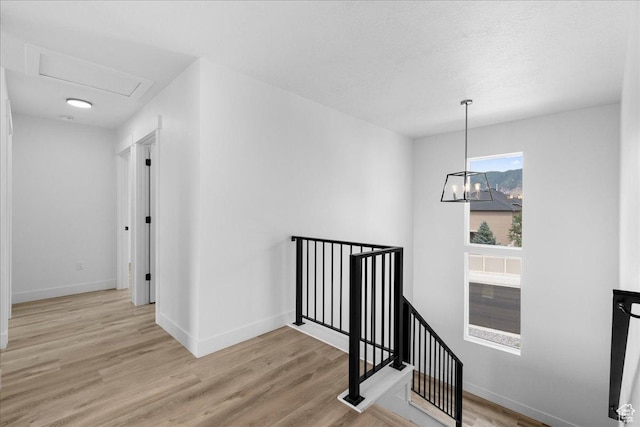 469 N 1360 E Unit 13, Tooele, UT 84074 - corridor with an upstairs landing, light wood-style flooring, and a chandelier