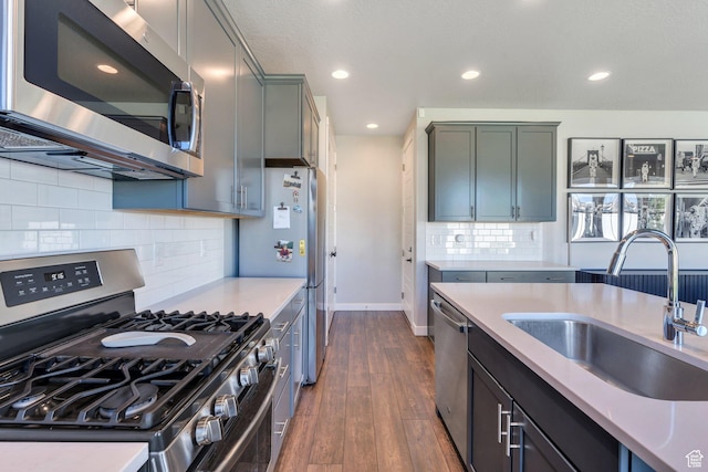 2739 N 3550 W, Lehi, UT 84043 - kitchen featuring appliances with stainless steel finishes, light countertops, dark wood finished floors, decorative backsplash, and recessed lighting