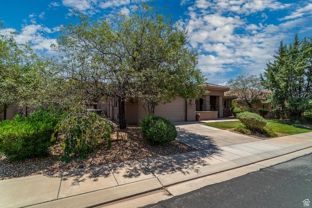 960 N Catalpa Dr, Washington, UT 84780 - view of front of home featuring concrete driveway, a garage, a tiled roof, and stucco siding