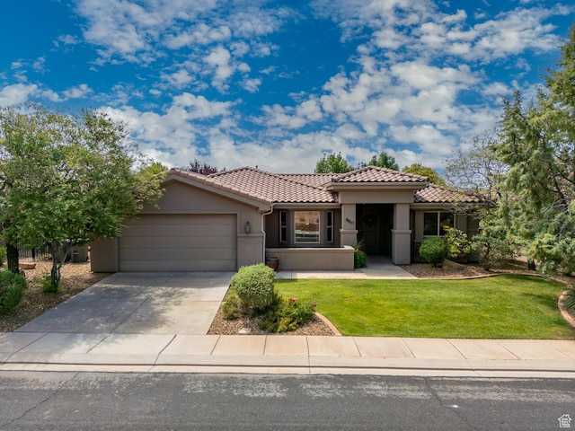 960 N Catalpa Dr, Washington, UT 84780 - mediterranean / spanish home featuring an attached garage, stucco siding, a tiled roof, concrete driveway, and a front lawn