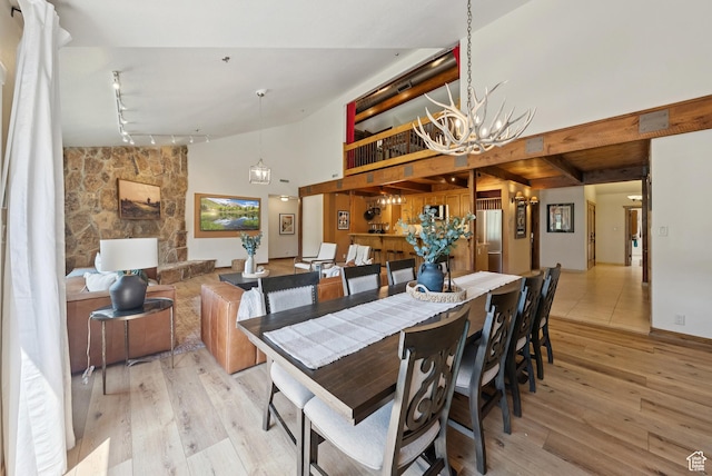1582 Deer Valley Dr N, Park City, UT 84060 - dining area featuring a chandelier, light wood-style flooring, high vaulted ceiling, and track lighting