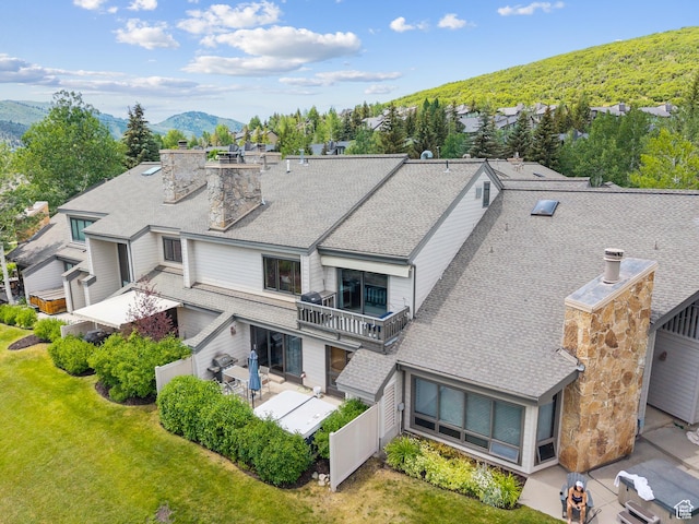 1582 Deer Valley Dr N, Park City, UT 84060 - back of property featuring a patio area, a yard, roof with shingles, a mountain view, and a chimney
