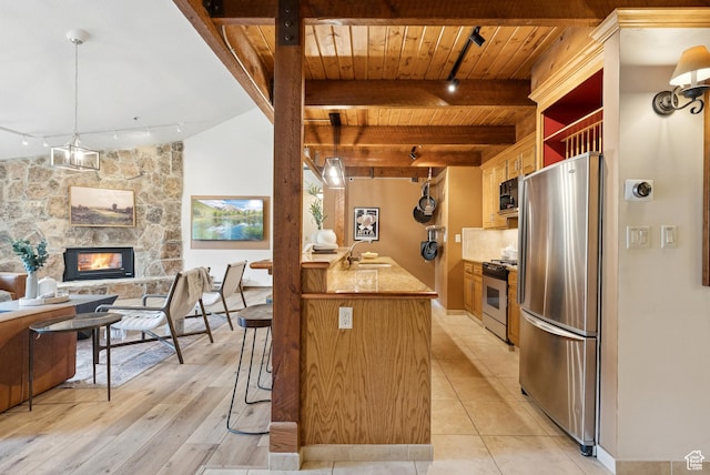 1582 Deer Valley Dr N, Park City, UT 84060 - kitchen featuring rail lighting, appliances with stainless steel finishes, a wooden ceiling with exposed beams, a stone fireplace, and open floor plan