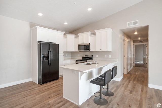1128 S 820 E Unit 1303, Heber City, UT 84032 - kitchen with appliances with stainless steel finishes, a breakfast bar area, light countertops, white cabinetry, and light wood-type flooring