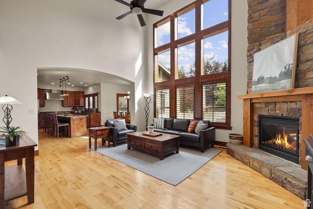 4048 W Ivy Ave, Mountain Green, UT 84050 - living area featuring a high ceiling, ceiling fan, arched walkways, light wood finished floors, and a fireplace