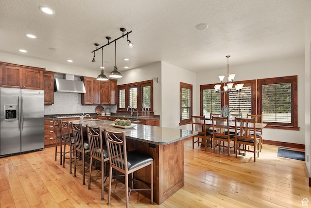4048 W Ivy Ave, Mountain Green, UT 84050 - kitchen with stainless steel fridge with ice dispenser, wall chimney exhaust hood, a textured ceiling, recessed lighting, and light wood finished floors