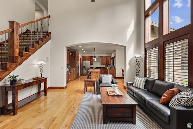 4048 W Ivy Ave, Mountain Green, UT 84050 - living area with a towering ceiling, light wood-type flooring, arched walkways, stairs, and recessed lighting
