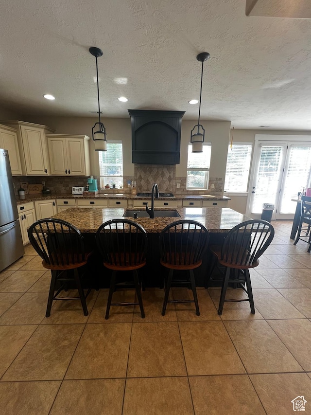 1694 S 710 E, Lehi, UT 84043 - kitchen featuring freestanding refrigerator, backsplash, dark stone countertops, a breakfast bar area, and a textured ceiling