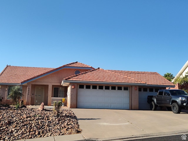 2054 E 140 S, St George, UT 84790 - ranch-style house featuring concrete driveway, an attached garage, a tiled roof, and stucco siding