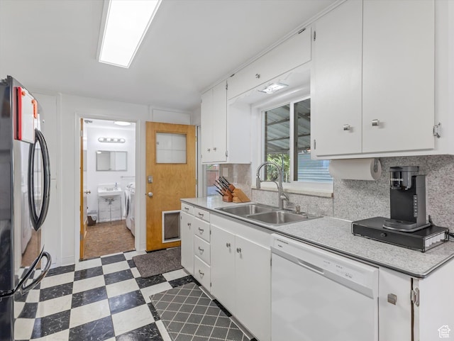 7645 W Gardenia Ave, Magna, UT 84044 - kitchen with dishwasher, freestanding refrigerator, dark floors, light countertops, and white cabinets