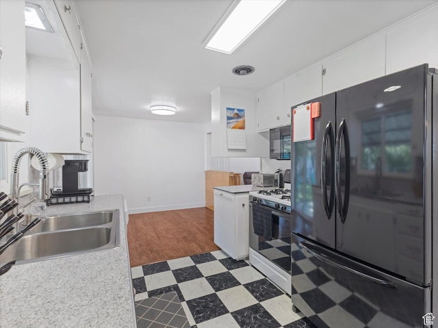 7645 W Gardenia Ave, Magna, UT 84044 - kitchen featuring black appliances, dark floors, light countertops, and white cabinets