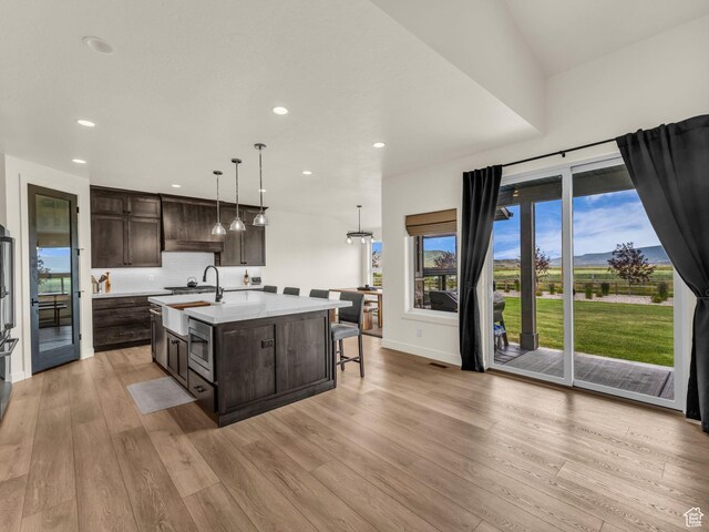 943 Hart Loop, Francis, UT 84036 - kitchen with dark brown cabinets, light countertops, recessed lighting, light wood-type flooring, and an island with sink