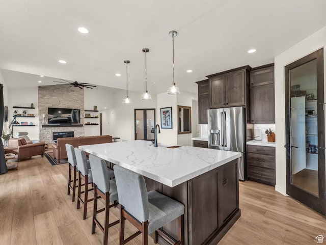 943 Hart Loop, Francis, UT 84036 - kitchen featuring high end fridge, light wood-style flooring, dark brown cabinets, ceiling fan, and a large island with sink