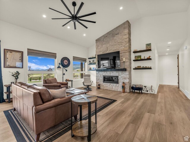 943 Hart Loop, Francis, UT 84036 - living room with light wood-type flooring, a stone fireplace, high vaulted ceiling, and recessed lighting