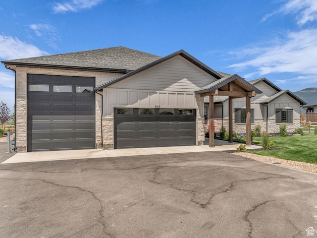 943 Hart Loop, Francis, UT 84036 - view of front of house featuring stone siding, a garage, board and batten siding, and asphalt driveway