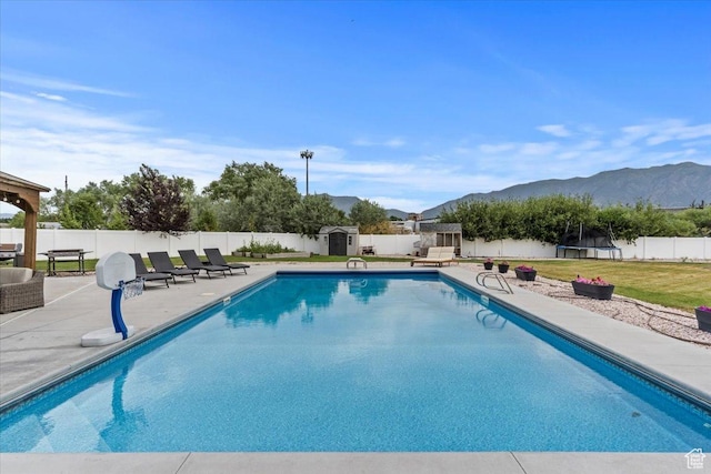 1820 W 950 N, Layton, UT 84041 - view of pool featuring a fenced backyard, a storage shed, a patio area, a mountain view, and a trampoline