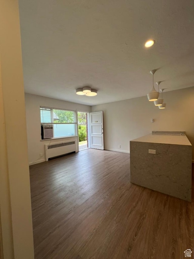 130 S 1300 E Unit 101, Salt Lake City, UT 84102 - unfurnished living room with radiator, dark wood finished floors, and recessed lighting