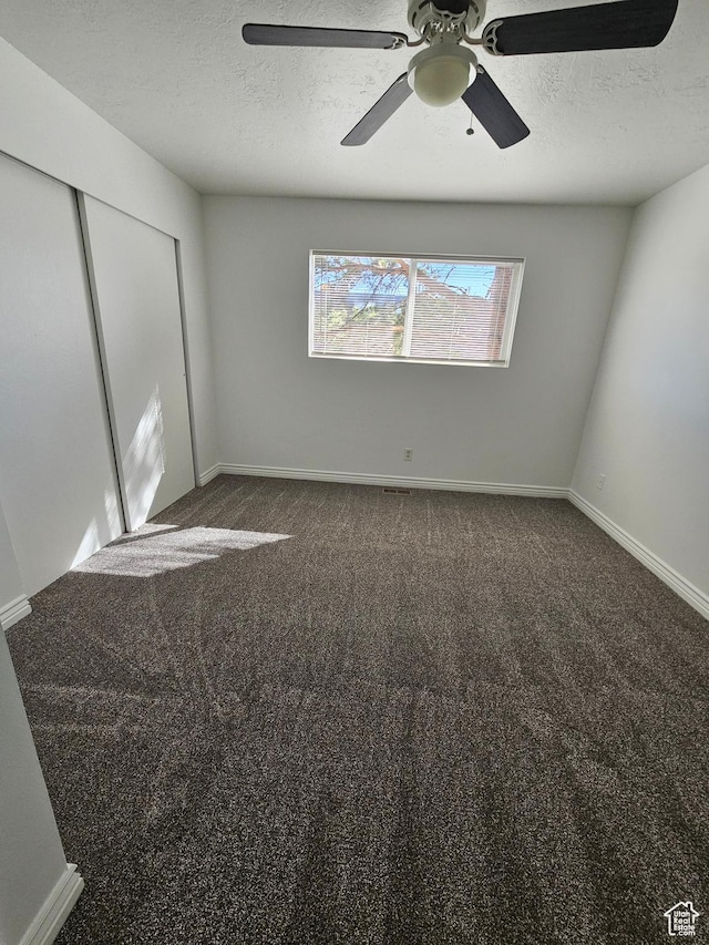 3673 S 2200 W Unit 15, West Valley City, UT 84119 - unfurnished bedroom featuring a textured ceiling, a closet, dark carpet, and a ceiling fan