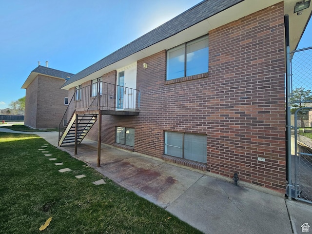 3673 S 2200 W Unit 15, West Valley City, UT 84119 - back of house with a yard, stairway, a patio, and brick siding