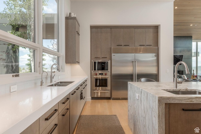 1433 Snow Berry St, Park City, UT 84098 - kitchen featuring built in appliances, light wood-style flooring, a warming drawer, light stone counters, and recessed lighting