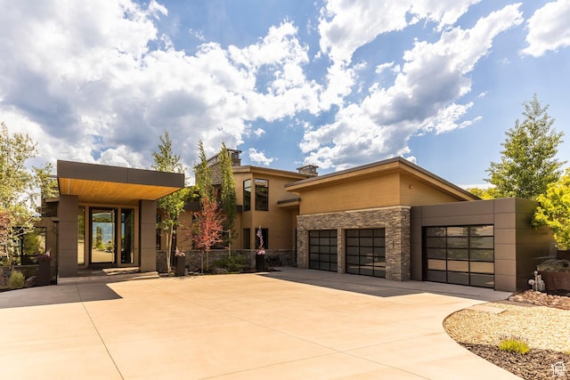 1433 Snow Berry St, Park City, UT 84098 - modern home with concrete driveway, stone siding, and an attached garage