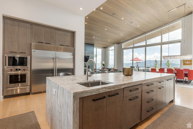 1433 Snow Berry St, Park City, UT 84098 - kitchen featuring built in appliances, a warming drawer, light wood finished floors, light stone counters, and expansive windows