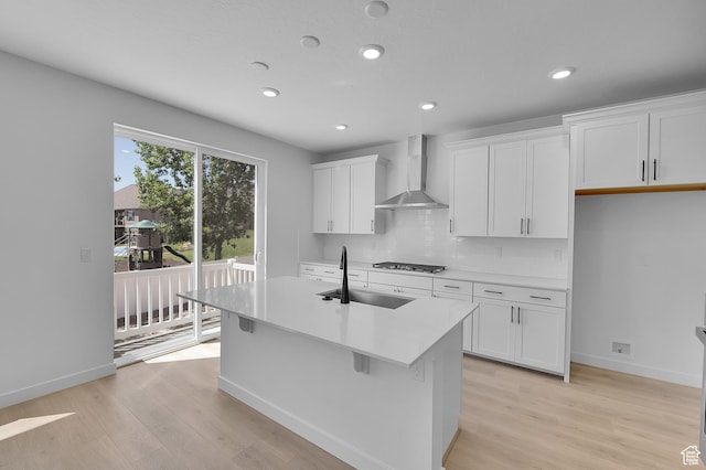 3362 S Zigzag Heron Dr Unit 813, Saratoga Springs, UT 84045 - kitchen with wall chimney range hood, light wood finished floors, an island with sink, white cabinets, and recessed lighting