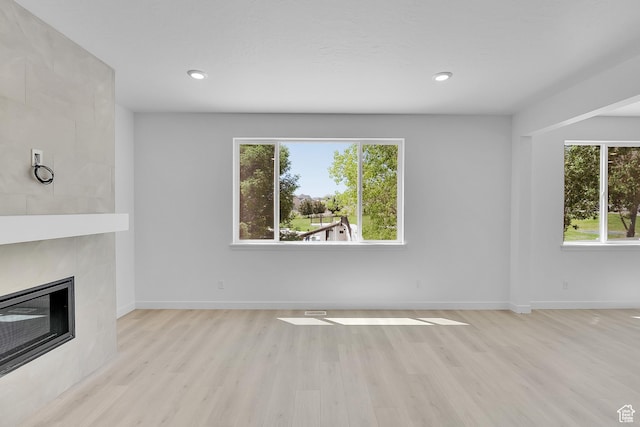 3362 S Zigzag Heron Dr Unit 813, Saratoga Springs, UT 84045 - unfurnished living room featuring healthy amount of natural light, light wood-style floors, a fireplace, and recessed lighting
