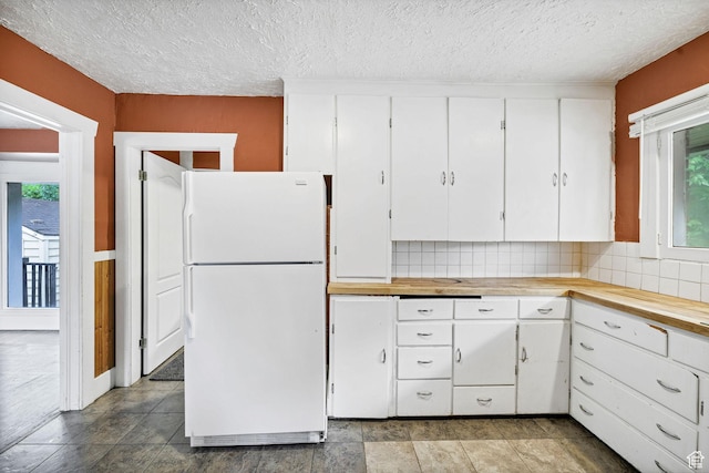 420 E 400 N, Logan, UT 84321 - kitchen featuring freestanding refrigerator, healthy amount of natural light, white cabinets, and a textured ceiling