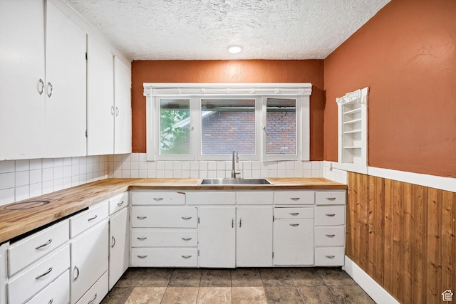420 E 400 N, Logan, UT 84321 - kitchen featuring butcher block countertops, decorative backsplash, a textured ceiling, white cabinets, and wood walls