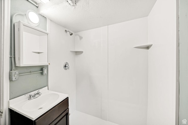 420 E 400 N, Logan, UT 84321 - bathroom featuring vanity, a shower, and a textured ceiling