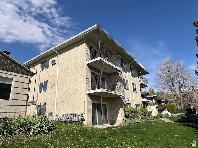 673 E 6th Ave, Salt Lake City, UT 84103 - rear view of property featuring brick siding, a yard, and a balcony