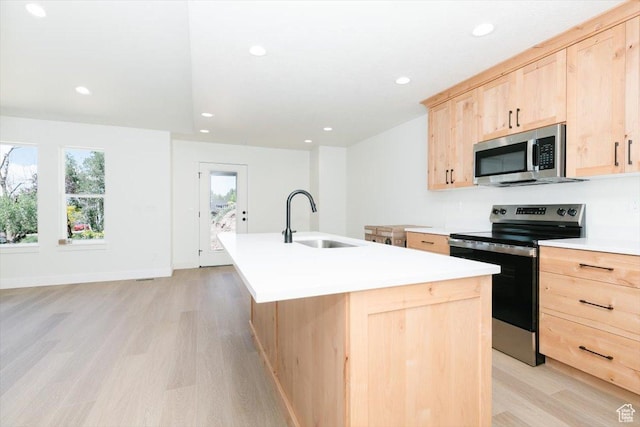 821 E 160 N, Hyde Park, UT 84318 - kitchen featuring light brown cabinets, stainless steel appliances, light wood-style flooring, a center island with sink, and light countertops