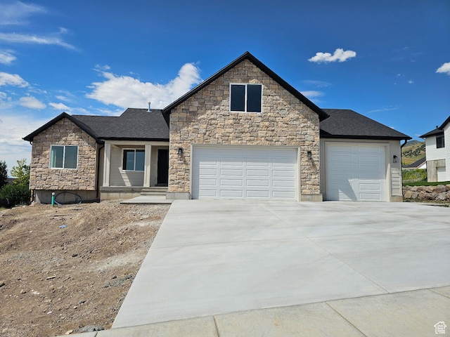 821 E 160 N, Hyde Park, UT 84318 - view of front of house featuring stone siding, an attached garage, driveway, and a shingled roof